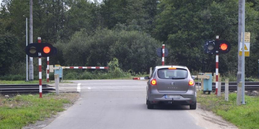 Haben Sie in dieser Situation das Recht, das vorausfahrende Fahrzeug auszuweichen, indem Sie auf den für die Gegenrichtung vorgesehenen Straßenabschnitt einfahren, wenn Sie es schaffen, vor dem Bahnübergang anzuhalten?